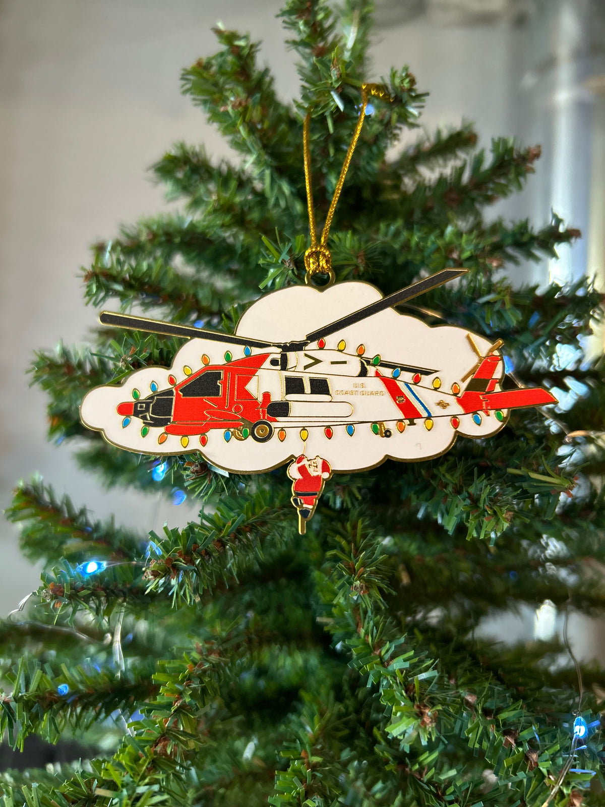 U.S. Coast Guard helicopter Christmas ornament with Santa hanging below, red and white on a white cloud with string lights